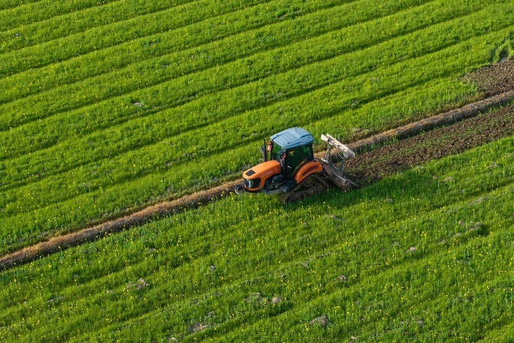 2024年3月19日，在湖南省常德市鼎城區(qū)謝家鋪鎮(zhèn)港中坪村，村民駕駛農(nóng)機(jī)翻耕田地（無(wú)人機(jī)照片）。新華社記者 陳思汗 攝