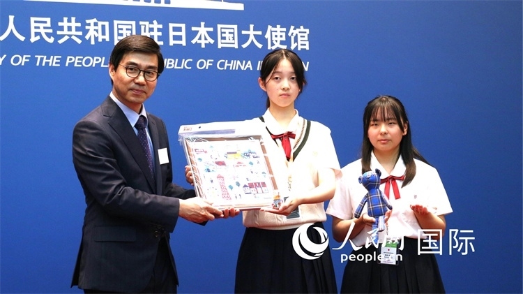 日本小大使向中國駐日本大使館臨時代辦施泳贈送當?shù)靥厣Y品。人民網(wǎng) 許可攝