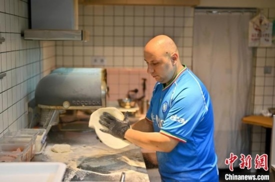 近日，韋榮耀在自家披薩小店內(nèi)忙活。俞靖 攝