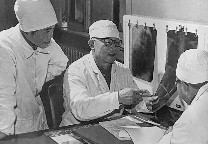 1980年1月16日，中日友好醫(yī)院首任院長辛育齡（中）在內(nèi)蒙古結(jié)核病院與胸外科醫(yī)師討論病例（翻拍照片）。 新華社發(fā)
