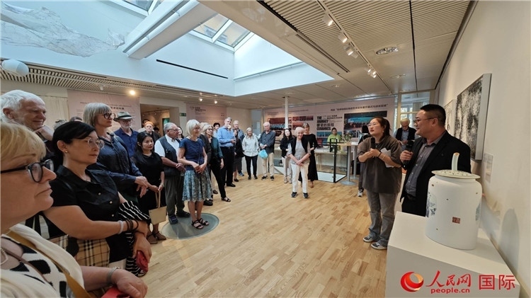 參展人、景德鎮(zhèn)陶瓷大學(xué)美術(shù)學(xué)院副院長邵長宗（右一）向來賓介紹參展作品。人民網(wǎng)記者 殷淼攝