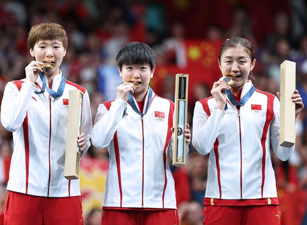 冠軍中國隊選手王曼昱、孫穎莎、陳夢（從左至右）在巴黎奧運會乒乓球女子團體頒獎儀式上（2024年8月10日攝）。新華社記者 王東震 攝