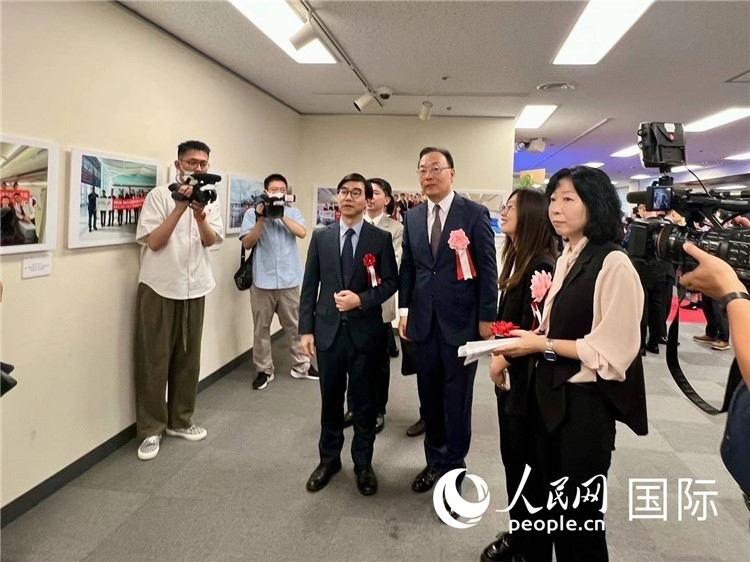 中國國際航空日韓地區(qū)支社支社長馮力為中國駐日本大使館臨時代辦施泳等嘉賓介紹展出圖片。人民網(wǎng) 許可攝
