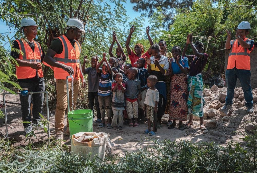 2023年6月13日，在坦桑尼亞姆萬扎省米松圭，工作人員接通水管后贏得當?shù)鼐用窆恼茪g呼。新華社記者 王冠森 攝