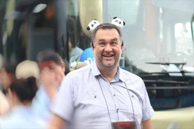 參訪熊貓谷前，塞爾維亞“一帶一路”研究所所長博揚·拉利奇戴上熊貓頭飾。（李佩藺 攝）