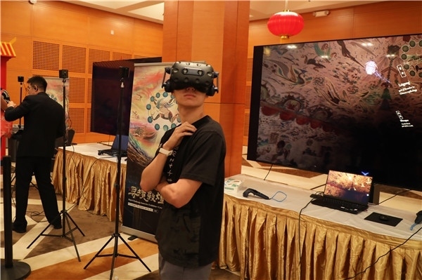 1、在本次活動(dòng)的展覽現(xiàn)場(chǎng)，敦煌研究院與騰訊展示了“數(shù)字藏經(jīng)洞”和“尋境敦煌”等創(chuàng)新互動(dòng)產(chǎn)品。圖為當(dāng)?shù)孛癖娡ㄟ^(guò)VR虛擬游覽洞窟。 人民網(wǎng)記者 李志偉攝