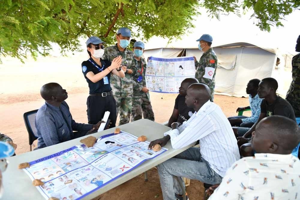 2020年3月，在南蘇丹首都朱巴，執(zhí)行聯(lián)合國維和任務(wù)的中國維和警察廖潔給當(dāng)?shù)鼐熘v解防疫知識。