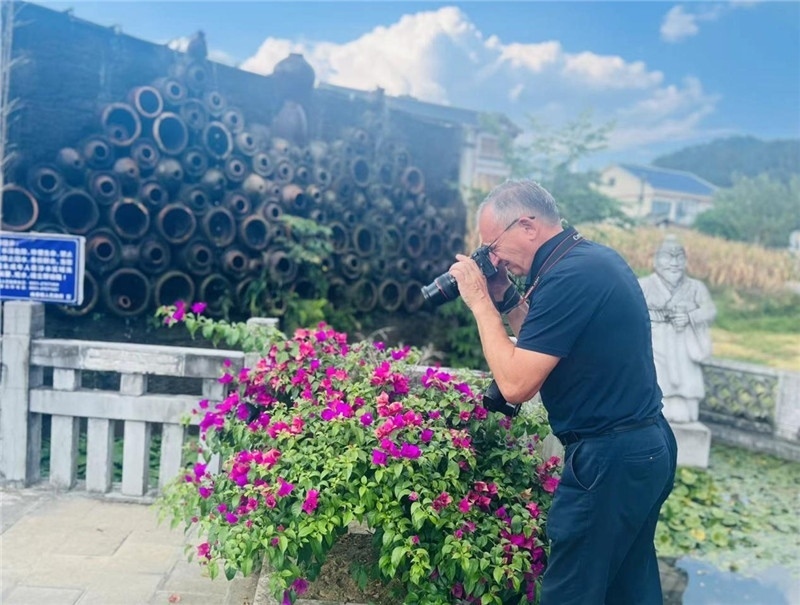 遠(yuǎn)處黔北民居錯(cuò)落有致，近處一只黑色的蝴蝶穿梭于粉紫色三角梅花叢間隙，與俄羅斯“大歐亞”總編輯弗拉基米爾·別列日內(nèi)赫的鏡頭玩起了捉迷藏，“你追我逃，不亦樂(lè)乎”。（張亞欣攝）