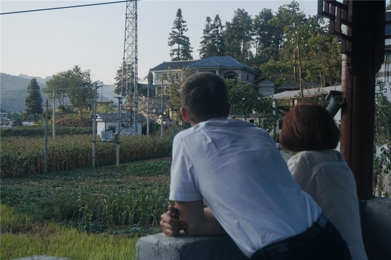 望得見(jiàn)山，看得見(jiàn)水，記得住鄉(xiāng)愁。每個(gè)人心中都有一個(gè)屬于自己的“花茂村”，在這方心田，走遍千山萬(wàn)水，鄉(xiāng)音未改鬢毛衰。吉爾吉斯斯坦《比什凱克晚報(bào)》第一副總編輯妮娜·尼奇博洛娃與《中國(guó)與俄羅斯》雜志社社長(zhǎng)奧列格·別列日內(nèi)赫攝在花茂村民居屋檐下并肩佇立，眺望山水，尋覓鄉(xiāng)愁。（李光裕攝）