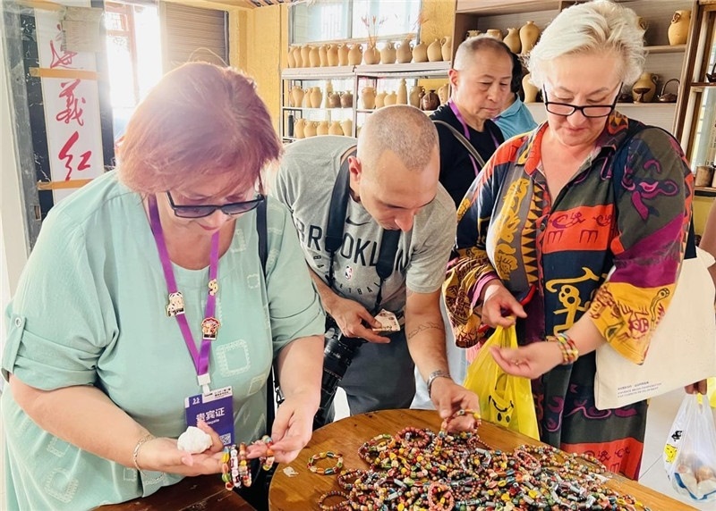 歐亞媒體考察團(tuán)成員在母氏陶藝館內(nèi)挑花了眼，色彩絢麗、質(zhì)地均勻的陶藝手串讓他們愛(ài)不釋手。“這里的東西都太實(shí)惠了！”塔吉克斯坦《索格特真理報(bào)》政論部主任娜塔利婭·多羅費(fèi)耶娃說(shuō)?；宓奶厣a(chǎn)品物美價(jià)廉，讓考察團(tuán)成員為家人好友買到了心儀的禮物，也為此次以四川成都為起點(diǎn)，路經(jīng)南充、廣安至貴州遵義的考察行程畫(huà)上了圓滿句號(hào)。（張亞欣攝）