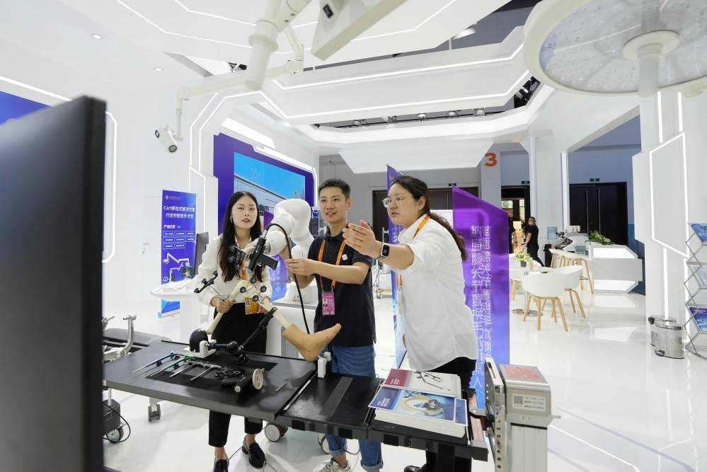 9月11日，一位媒體記者（中）在2024年服貿(mào)會(huì)國(guó)家會(huì)議中心會(huì)場(chǎng)體驗(yàn)北京納通科技集團(tuán)有限公司的膝關(guān)節(jié)置換手術(shù)機(jī)器人。新華社記者鞠煥宗 攝