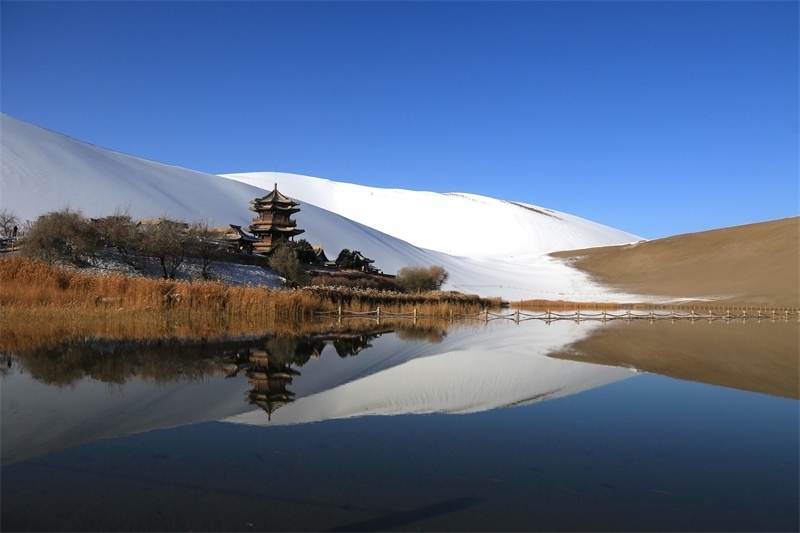 鳴沙山月牙泉景區(qū)雪景。敦煌市委宣傳部供圖，張曉亮攝