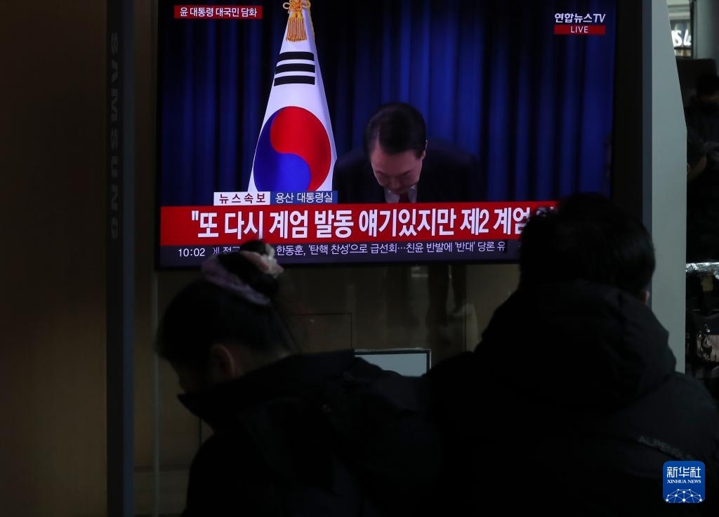 12月7日，在韓國(guó)首爾火車站，民眾觀看總統(tǒng)尹錫悅發(fā)表講話的電視畫面。新華社記者 姚琪琳 攝