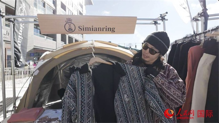 藤田周正在展示自己設(shè)計的滑雪服。人民網(wǎng)記者 袁蒙攝