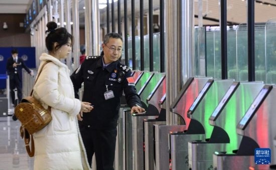 1月2日，大興機(jī)場(chǎng)邊檢站警察指導(dǎo)旅客使用自助出境設(shè)備。新華社記者 李欣 攝