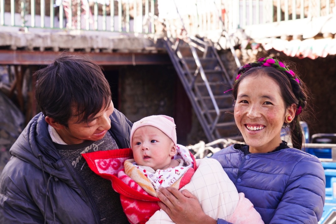 1月11日，在西藏日喀則市人民醫(yī)院，受災(zāi)群眾抱著自己在地震中受傷的孩子康復出院。人民日報記者徐馭堯攝