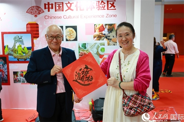本地觀眾在中國文化體驗區(qū)展示書法作品。人民網(wǎng)記者 白元琪攝