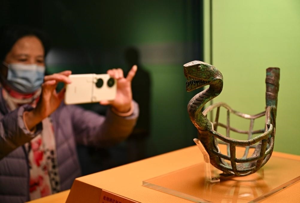 1月14日，觀眾在上海博物館蛇年迎春展拍攝展品蛇綱網(wǎng)狀銅器。新華社發(fā)（陳浩明攝）