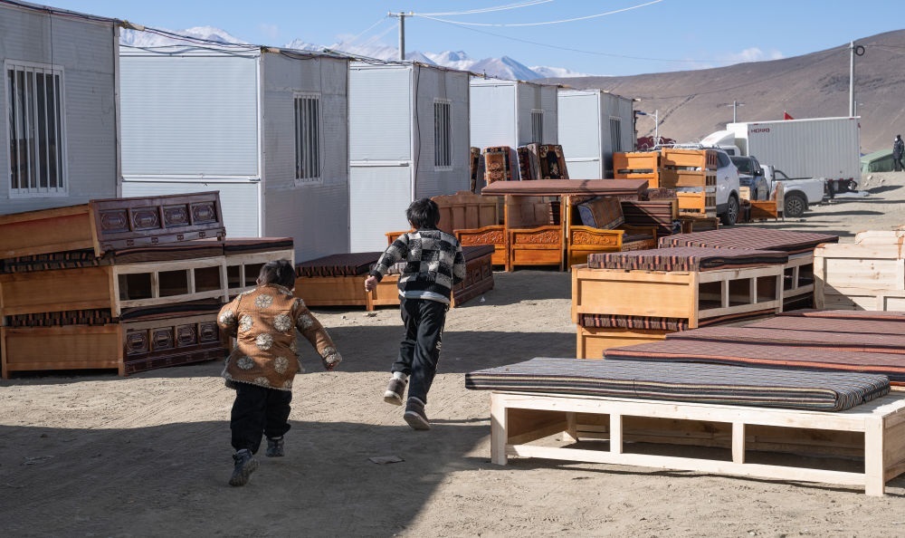 2025年1月13日，在定日縣嘎旦村，兩個孩子在剛運來的兩排藏床間奔跑。新華社記者丁增尼達 攝