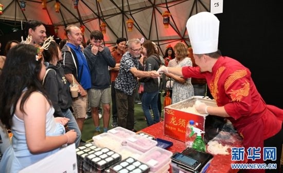 圖為游客在燈節(jié)現(xiàn)場購買小吃。（圖片由奧克蘭中國文化中心提供）