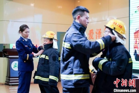 圖為學(xué)生們現(xiàn)場(chǎng)穿戴消防頭盔和戰(zhàn)斗服。中新社記者 趙宇航 攝