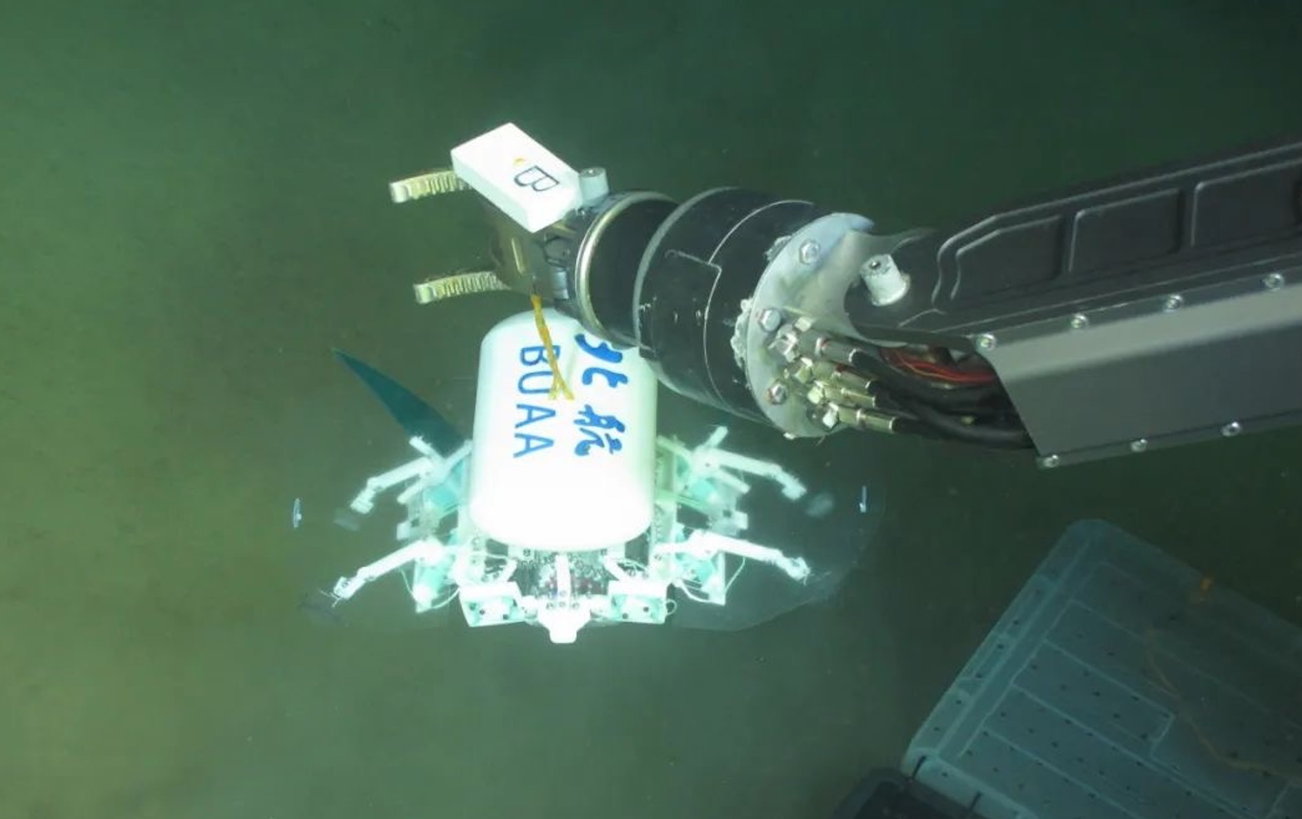 科研人員利用機(jī)械臂將北航深海小型機(jī)器人投于馬里亞納海溝。校方供圖