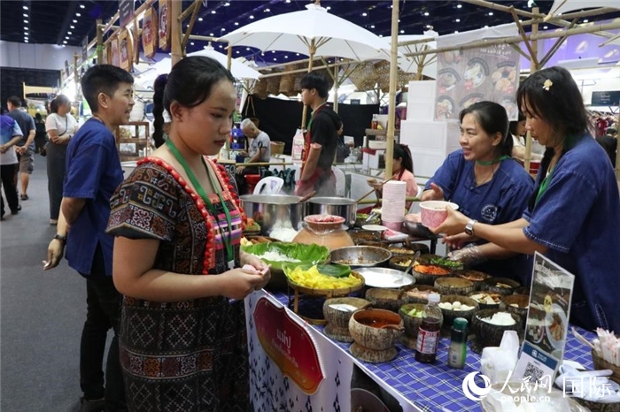 游客在攤位前購買特色美食。朱瀟逸攝