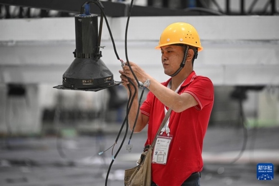 4月4日，工作人員在海南國(guó)際會(huì)展中心內(nèi)布設(shè)燈光。