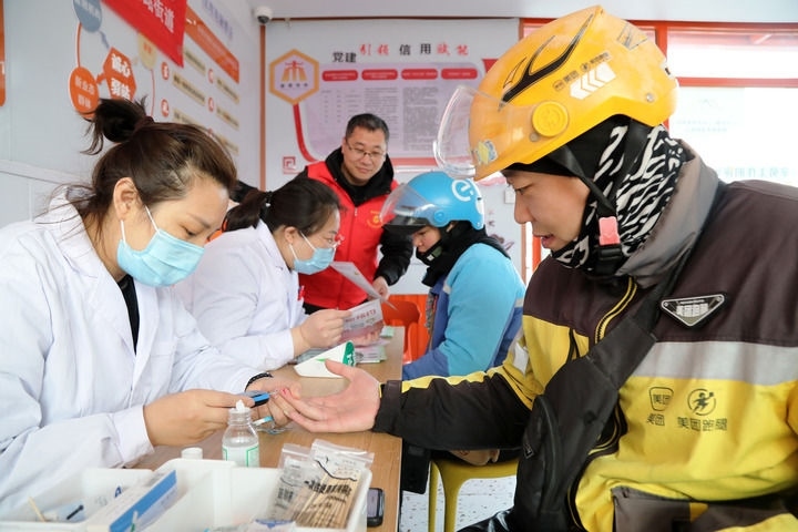 2025年3月5日，志愿者在山東省棗莊市市中區(qū)一工會驛站為外賣員免費(fèi)測量血糖。新華社發(fā)（王海楠攝）