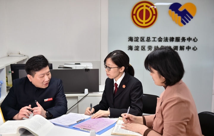 2025年3月6日，在北京市海淀區(qū)總工會勞動爭議調(diào)解中心，海淀區(qū)人民法院法官王琰（中）與該中心工作人員就糾紛化解情況進(jìn)行溝通。新華社記者 趙婷婷 攝