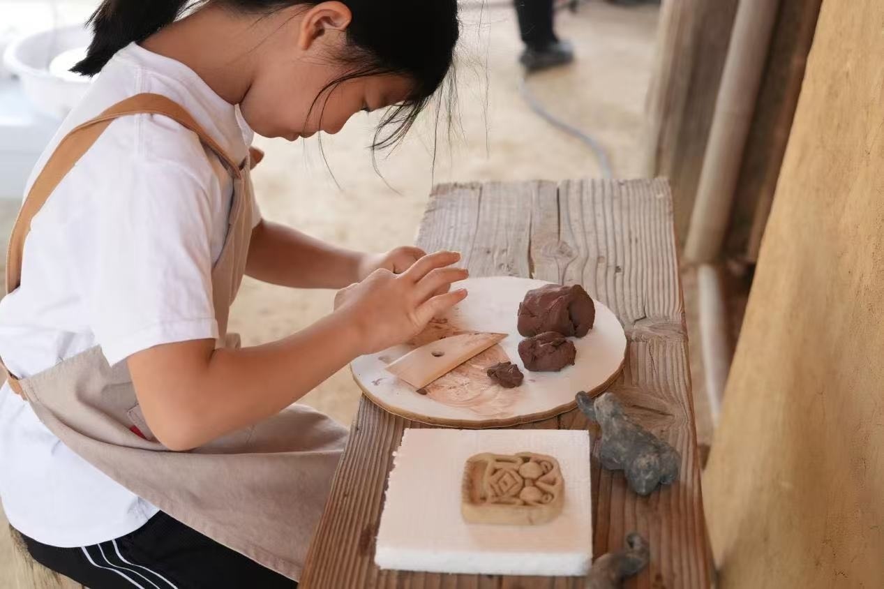 游客制作良渚特色陶藝品。良渚博物院供圖
