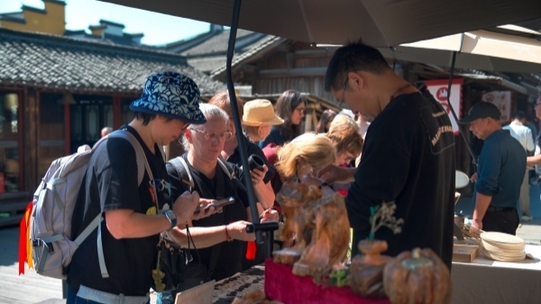 “五一”期間，游客正在烏鎮(zhèn)“水鄉(xiāng)碼頭”挑選購買文創(chuàng)產(chǎn)品。受訪者供圖