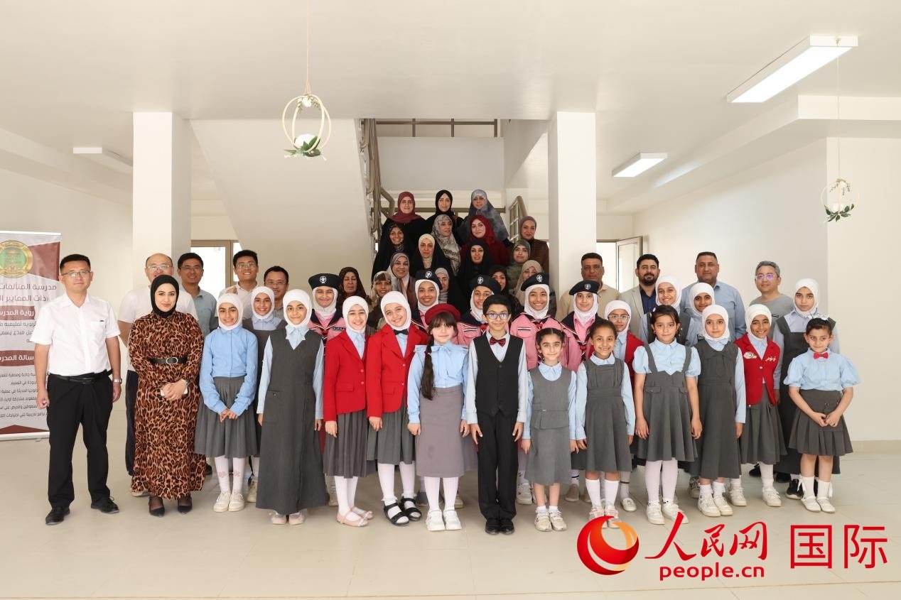 中國電建員工與阿爾穆塔?阿里卡特國際學(xué)校的師生及政府官員等合影。人民網(wǎng)記者 薛丹攝
