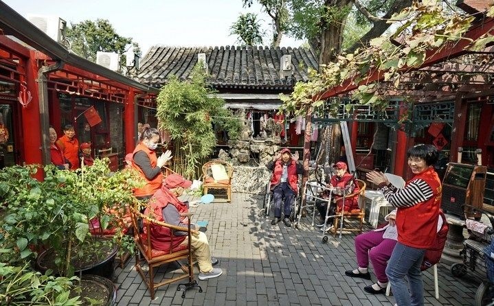 2024年10月12日，鐘樓灣胡同的老年人在社區(qū)內(nèi)的四合院養(yǎng)老驛站休閑。2017年起，北京市先后開展了兩輪背街小巷環(huán)境整治提升行動(dòng)，完整保留了中軸線生活建筑群的歷史信息，并根據(jù)居民的生活和居住方式進(jìn)行適配化的更新和改造，極大地改善了生活環(huán)境。2023年鐘樓灣胡同被評(píng)為“北京最美街巷”。