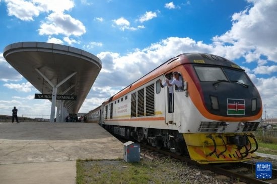 5月31日，在蒙內(nèi)鐵路內(nèi)羅畢站，機車駕駛員蔣立平（右）和博爾在即將開往蒙巴薩的E2次列車上揮手致意。新華社記者 楊光 攝