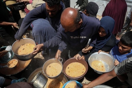 5月28日，人們在加沙城西部的沙提難民營領取救助食物。新華社發(fā)（里澤克·阿卜杜勒賈瓦德攝）