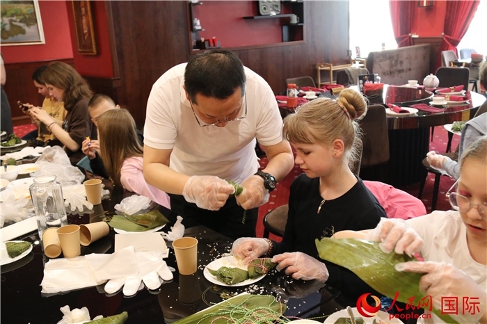烏克蘭兒童學(xué)習(xí)體驗包粽子。人民網(wǎng)記者蔡子暢攝