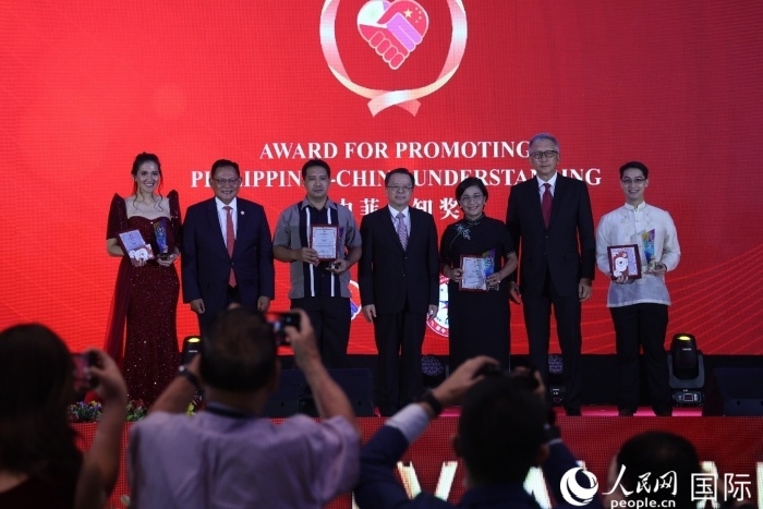 黃溪連大使和菲中了解協(xié)會主席與榮獲“友誼獎”的獲獎者合影留念。人民網(wǎng)記者 樊帆攝